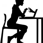 Silhouette of a person at a desk using a laptop and phone, highlighting multitasking and technology use.