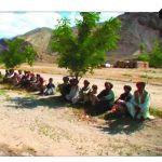 People sitting under trees in a desert landscape, with a person in a library inset in the corner.